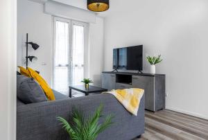 a living room with a gray couch and a flat screen tv at 2 Bedrooms Apt with Terrace - NoLo area in Milan