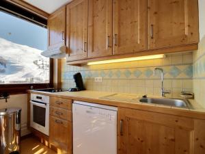a kitchen with wooden cabinets and a sink at Grand appartement pour 6 au pied des pistes, lumineux avec balcon - FR-1-455-165 in La Plagne +14 photos