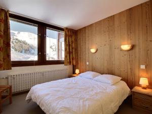 a bedroom with a bed and a large window at Grand appartement pour 6 au pied des pistes, lumineux avec balcon - FR-1-455-165 in La Plagne