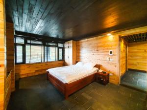 1 dormitorio con 1 cama en una habitación de madera en Phủ Giáng Vân Homestay Sapa en Sa Pa