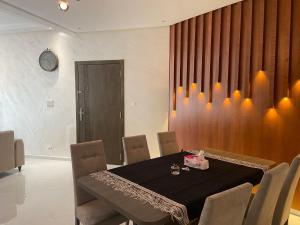 a dining room with a black table and chairs at Bloemen Huis in Fès