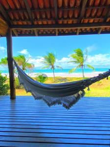 a hammock on a beach with palm trees at Pousada Bahia Boa in Marau