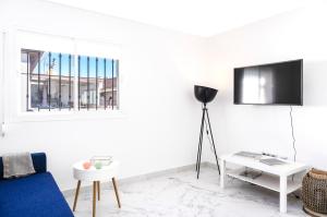 - un salon avec une télévision sur un mur blanc dans l'établissement Lovely 2-bedroom home in Pueblo Nuevo de Guadiaro, à Guadiaro