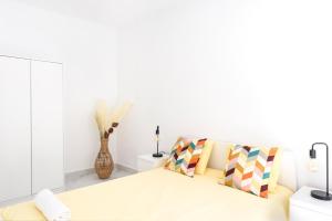 ein weißes Wohnzimmer mit einem Sofa und einer Vase in der Unterkunft Lovely 2-bedroom home in Pueblo Nuevo de Guadiaro in Guadiaro