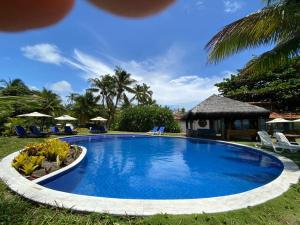 a pool at a resort with chairs and a gazebo at Pousada Bahia Boa in Marau
