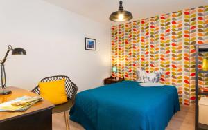 a bedroom with a blue bed and a colorful wall at Roomerie in Sulzbach-Rosenberg