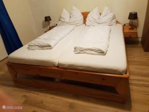 a bed with white sheets and pillows on it at Haus Leonie in Bramberg am Wildkogel