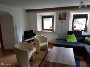 a living room with a couch and a table at Haus Leonie in Bramberg am Wildkogel
