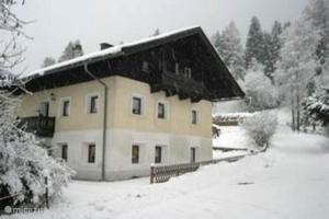 a house covered in snow in front at Haus Leonie in Bramberg am Wildkogel