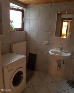 a bathroom with a washing machine and a sink at Haus Leonie in Bramberg am Wildkogel
