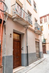 - Edificio con puerta de madera y balcón en QH Realejo - Varela, en Granada