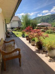 a wooden bench sitting on a porch with potted plants at Auberge de France in Kruth