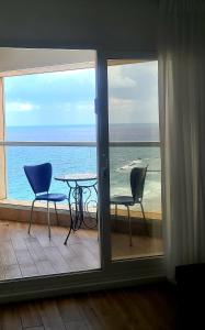 a view of the ocean from a balcony with a table and chairs at GO to apartments in Leonardo in Bat Yam