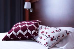 Rúm í herbergi á Hôtel Val-Vignes Colmar Haut-Koenigsbourg, The Originals Relais