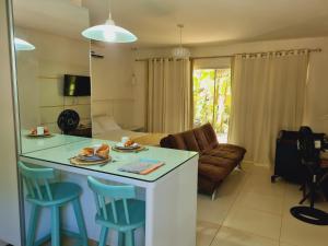 uma cozinha e sala de estar com mesa e cadeiras em Villas do Pratagy Maceió em Maceió