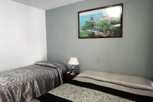 a room with two beds and a picture on the wall at Casa Amigos de Barcelo Appartement 1 in Cienfuegos