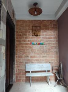 uma parede de tijolos com um banco contra uma parede de tijolos em Pousada Rústica em São Thomé das Letras