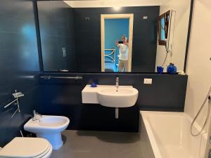 帕勞的住宿－Sardegna home luxury b&b，画着浴室的人,浴室里设有水槽和厕所