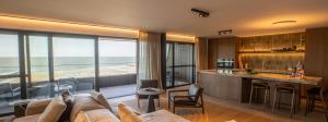 a living room with a view of the ocean at Kezand, Seaview beach apartment with cozy atmosphere in Cadzand