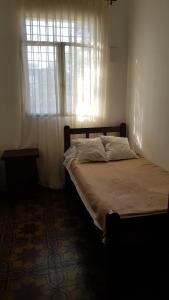 łóżko w pokoju z oknem i łóżko sidx sidx sidx w obiekcie Casa barrio norte w mieście San Miguel de Tucumán