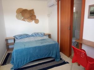 sypialnia z łóżkiem i czerwonym krzesłem w obiekcie MRG Dúplex Novo Francês w mieście Marechal Deodoro