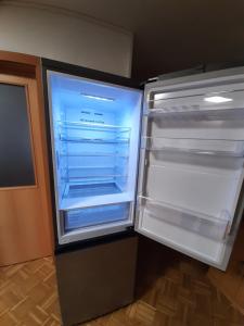 an empty refrigerator with its door open in a room at Schöne Wohnung am Bauernhof 