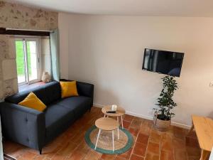 sala de estar con sofá azul y mesa en Studio à 20 min des cures thermales de La Roche Posay - Casino, en Archigny