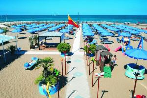 una spiaggia con ombrelloni e sedie blu e l'oceano di Hotel Union a Riccione