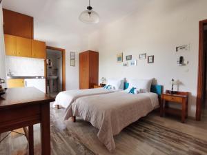 a bedroom with two beds and a desk and a kitchen at Ostria Rooms in Palaiochora