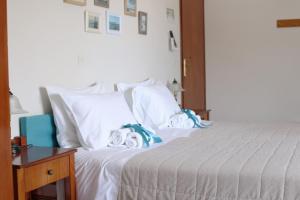 1 dormitorio con cama con almohadas blancas y mesa en Ostria Rooms en Palaiochóra