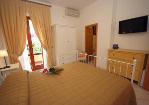 - une chambre avec un lit fleuri dans l'établissement Hotel Anna, à Fetovaia