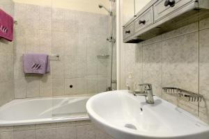 bagno con lavandino e vasca di Palheiro Residence Familiar 1 a Funchal