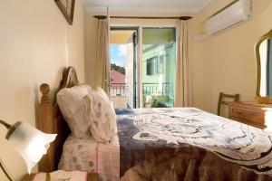 un dormitorio con una cama y una ventana en Palheiro Residence Familiar 1, en Funchal