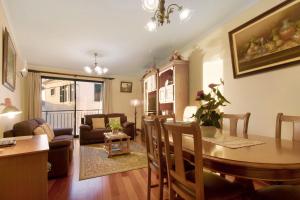 una sala da pranzo e un soggiorno con tavolo e sedie. di Palheiro Residence Familiar 1 a Funchal