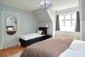 1 dormitorio con cama y espejo en Stylish 5 Person Flat in Vibrant Urban Area en Copenhague