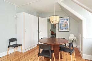 哥本哈根的住宿－Stylish 5 Person Flat in Vibrant Urban Area，一间带木桌和椅子的用餐室