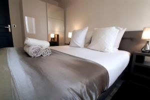 een slaapkamer met een groot bed met witte lakens en kussens bij Spacious Apartment in Paris Place des Fetes in Parijs