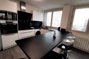 een keuken met een zwart aanrecht in een kamer bij Spacious Apartment in Paris Place des Fetes in Parijs