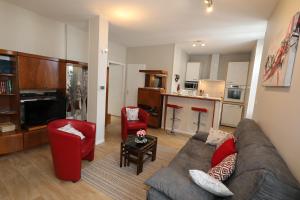 a living room with a couch and chairs and a kitchen at Le Florès Idéalement situé Centre Luz Appart T3 6 personnes Parking in Luz-Saint-Sauveur