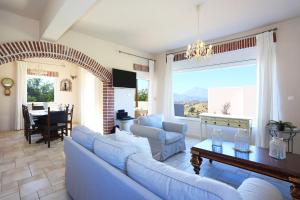 a living room with blue couches and a table at Listaros Villas in Lístaros
