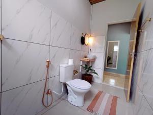 ein weißes Bad mit einem WC und einer Dusche in der Unterkunft Casa agradável com jacuzzi, área de lazer, enxoval in Andradina