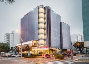 un gran edificio de cristal en una ciudad con aparcamiento en Nobility Grand Hotel, en Lima