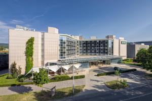 Quality Hotel Brno Exhibition Centre في برنو: مبنى مكتب كبير أمامه ساحة