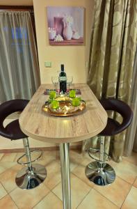a wooden table with a plate of fruit and wine glasses at Vicky's House in Bük