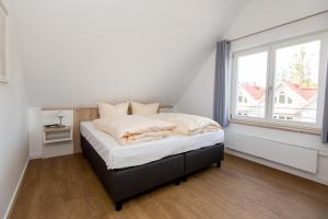 Cama en habitación con ventana grande en 4 Zimmer Maisonette 3 Balkone Haus 6 A6 Nr 43 en Plau am See