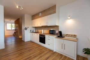a kitchen with white cabinets and a counter top at Becci's Apartment P6A8 in Plau am See