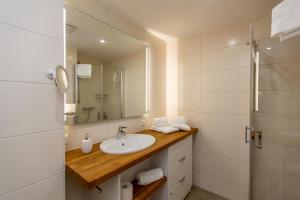 ein Badezimmer mit Waschbecken und Spiegel in der Unterkunft Becci's Apartment P6A8 in Plau am See