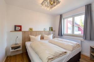 ein Schlafzimmer mit einem großen Bett mit Fenster in der Unterkunft Becci's Apartment P6A8 in Plau am See