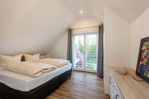 ein Schlafzimmer mit einem Bett und einem großen Fenster in der Unterkunft Becci's Apartment P6A8 in Plau am See