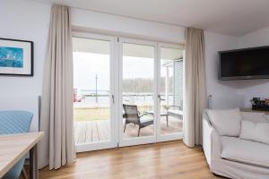 een woonkamer met een glazen schuifdeur en een patio bij Haus 7 Apartment 2 Hundefreundlich in Plau am See